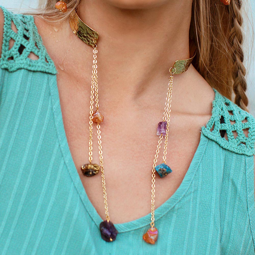 Décolletage close up of Raye necklace gold cuff with dripping multi-coloured raw stones and turquoise top