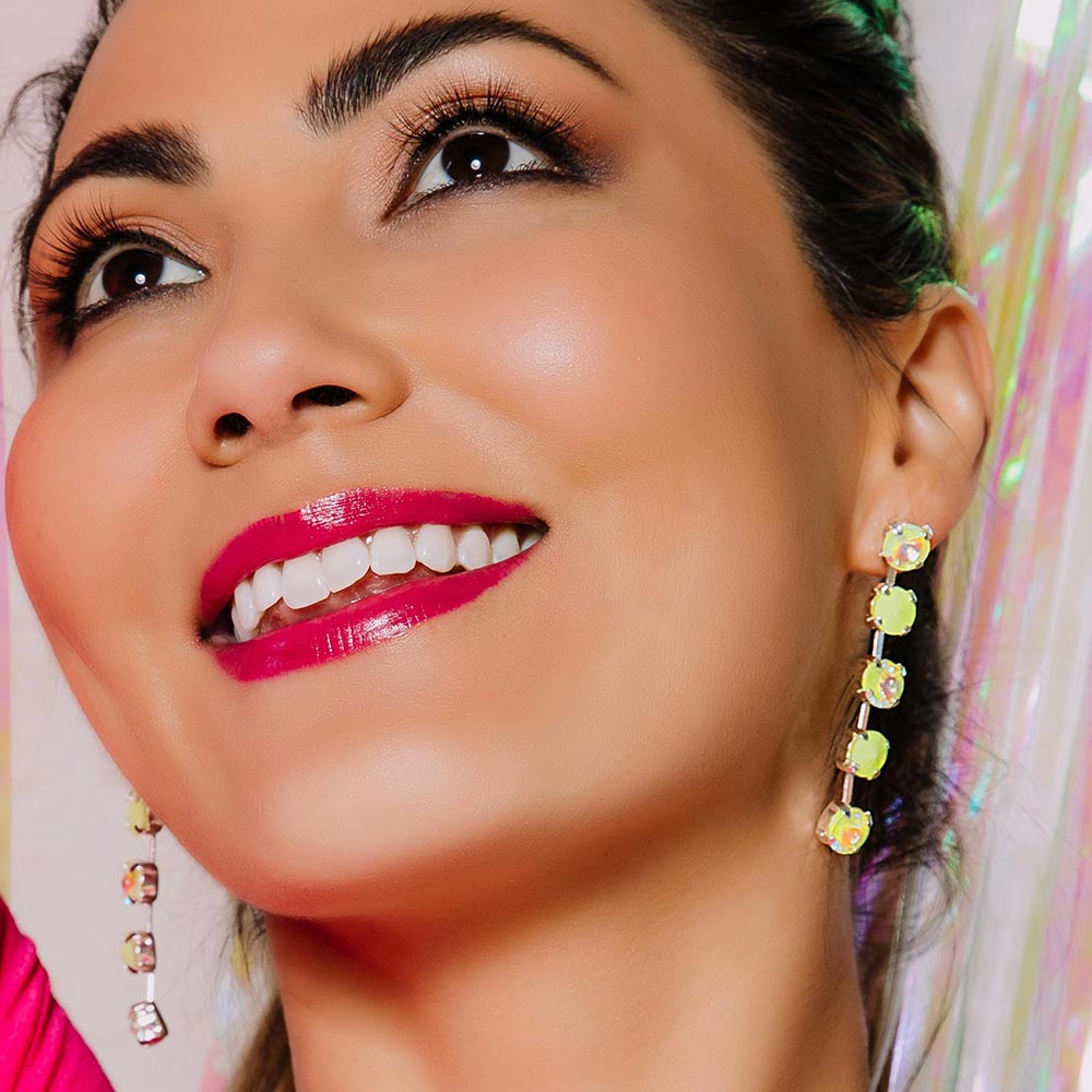 Daiquiri neon yellow crystal earrings, model looking up smiling